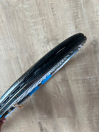 Close-up of two tennis rackets stacked, featuring a pre-owned Babolat Pure Drive VS 4 3/8, viewed from the side on a light wooden floor—ideal for advanced players seeking precision.